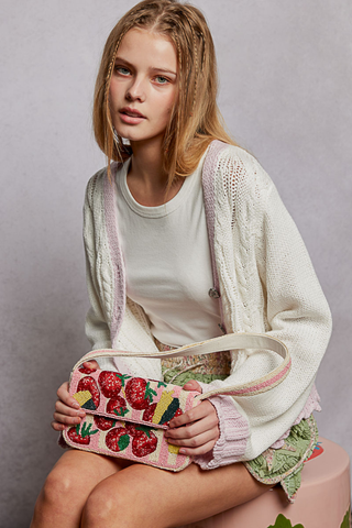POL Pink Beaded Fruit Pattern Shoulder Flap Bag Woman holding a handbag with strawberry design against a plain background