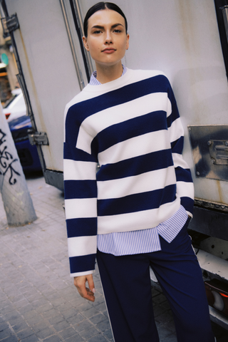 Person wearing a blue and white striped sweater with a plain background b. young BYOtari Stripe Sweater
