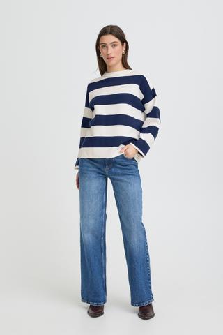 Woman wearing a navy and white striped sweater with blue jeans on a white background b. young BYOtari Stripe Sweater