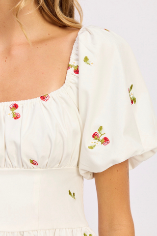 White dress with floral embroidery on a plain background En Saison Strawberry Kiss Embroidered Peplum Top