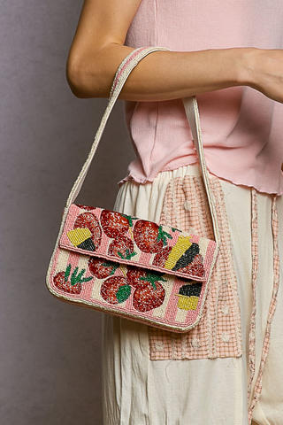 Pink Beaded Fruit Pattern Shoulder Flap Bag Person holding a pink embroidered handbag with fruit patterns against a neutral background