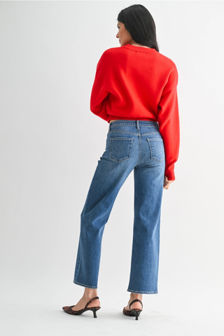 Just Black BP511J The Refined Mid Rise Slim Wide Leg  Person wearing a red sweater and blue jeans on a white background