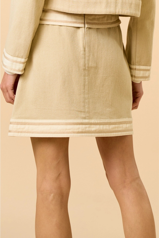 lalavon ILK5665 Neutral Colorblock Mini Skirt Beige skirt with white trim worn by a person on a beige background