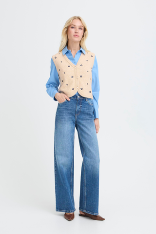 BYNadika Embroidered Vest Woman wearing a blue shirt, beige vest, and jeans on a white background