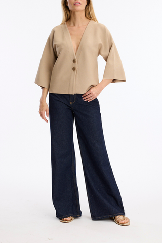 Leo & Ugo AE128 Marie Structured V-Neck Top with Wide Sleeves  Woman wearing a beige blouse and dark blue jeans on a white background