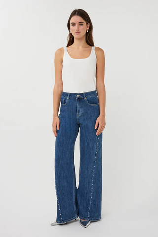 EsQualo SP2612018 Wide Fit Trouser Jeans with Studs Woman wearing a white tank top and blue jeans on a light gray background