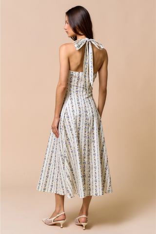 lalavon ILD6700 Bluebell Floral Halter Midi Dress Woman wearing a floral dress with a halter neck design on a beige background