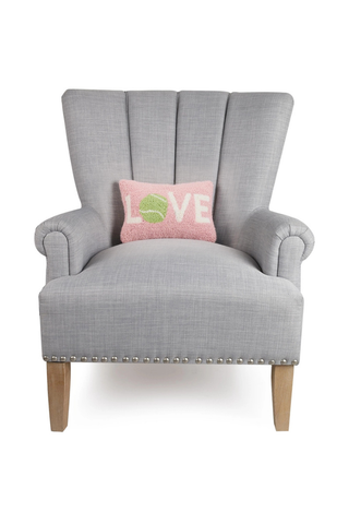 Gray armchair with a pink pillow featuring green text on a white background
