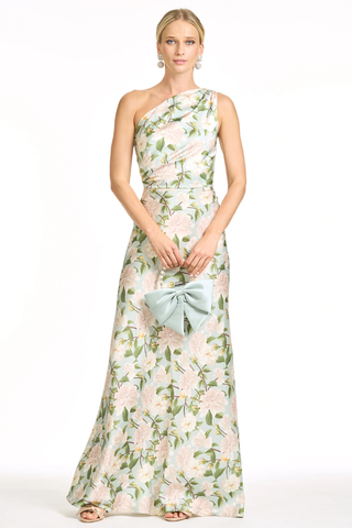 Sachin & Babi Delphine Gown - Celadon Sweetbriar S263G45-336 Woman wearing a floral one-shoulder dress with a bow clutch on a white background