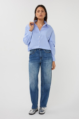 EsQualo SP2628002 Striped Batwing Blouse Woman wearing a light blue striped shirt and blue jeans on a white background