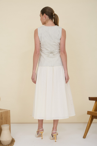 Zoe and Claire SP1065 Striped Vest Top Twofer Dress Woman wearing a white dress with a belt against a beige background