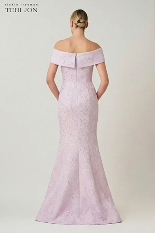 Teri Jon 266012 Jacquard Asymmetrical Off The Shoulder Side Bow Godet Gown Woman wearing a light purple off-shoulder evening gown on a white background