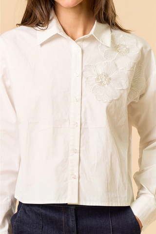 lalavon ILT6382 Off White Floral Appliqué Button Down Shirt  White blouse with floral embroidery on a beige background