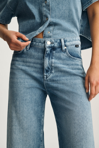 M1010914-A1427 Paloma Wide Leg Jeans Person wearing a light blue denim shirt and jeans on a plain background