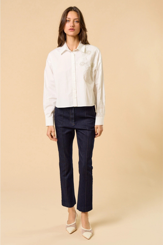 lalavon ILT6382 Off White Floral Appliqué Button Down Shirt  Woman wearing a white blouse and navy pants on a beige background