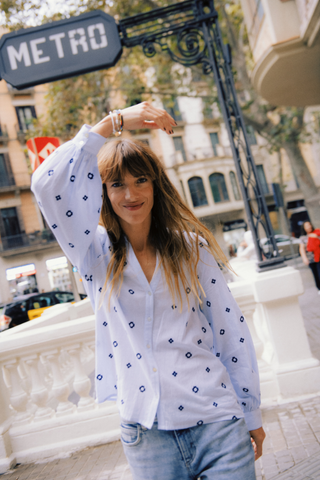 Woman in a white blouse with blue patterns standing in front of a 'METRO' sign. b. young BYFabienne Long Sleeve Shirt
