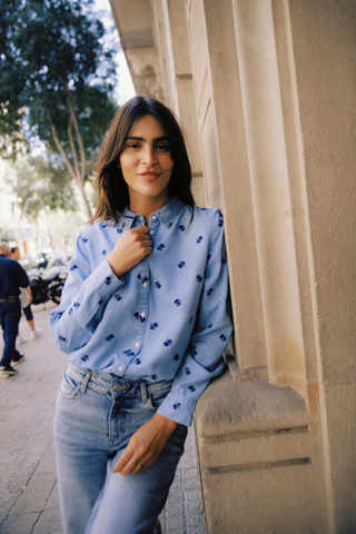 Woman wearing a blue patterned shirt and jeans standing against a building. b. young BYKosmo Boho Embroidered Shirt