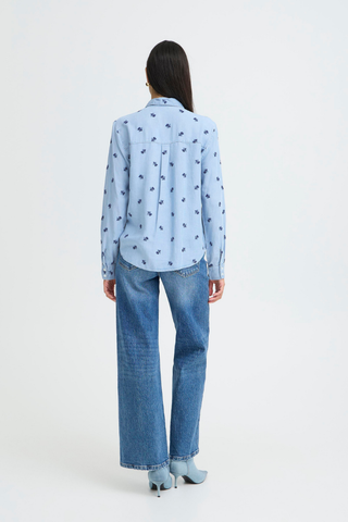 Person wearing a light blue shirt with black patterns and jeans on a white background b. young BYKosmo Boho Embroidered Shirt