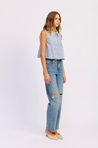 Woman wearing a striped sleeveless top and ripped jeans on a white background En Saison Clara Striped Sleeveless Top with Eyelet Collar