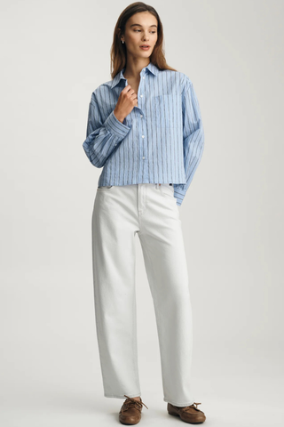 Cropped One Pocket Button-Up Shirt Mavi M1211363-86599 Woman wearing a blue striped shirt and white pants on a plain background