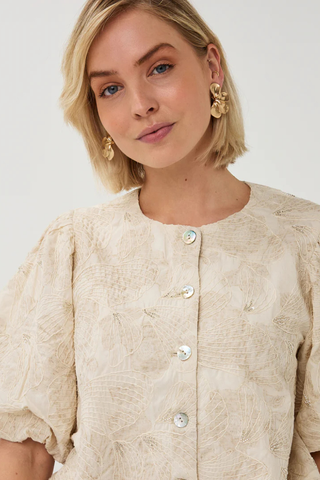 EsQualo SP2628005 Top Balloon 3D Shell Print Woman wearing a beige textured blouse with buttons on a white background