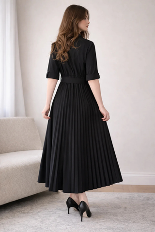 Leo & Ugo EER620 Black Tie-Waist Midi Shirt Dress Woman wearing a black dress standing in a room with a neutral color scheme.