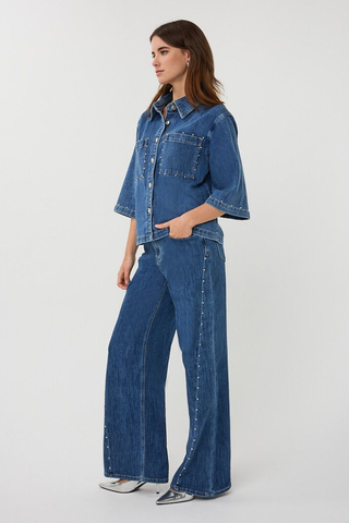 EsQualo SP2612016 Denim Blouse with Studs Woman wearing a blue denim jacket and jeans on a white background