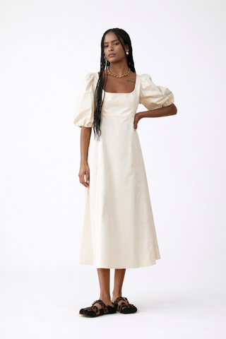 BLANCA Carmelita Dress Woman wearing a white dress with puffed sleeves on a white background
