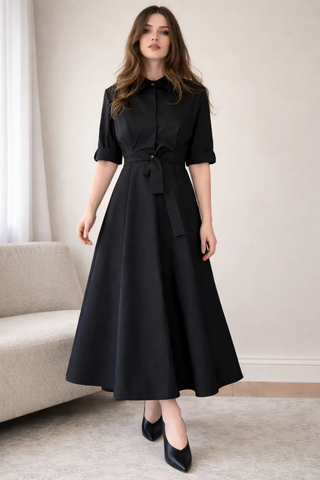 Leo & Ugo EER620 Black Tie-Waist Midi Shirt Dress Woman wearing a black dress in a minimalistic room.