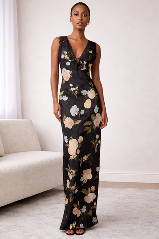Lulus Judith Lace Trim Maxi Dress WS-D0056 Woman wearing a floral jumpsuit in a room with a white couch.
