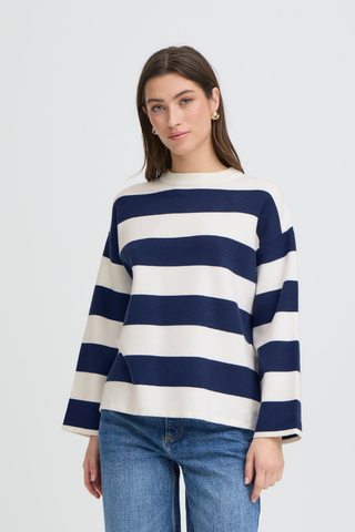 Woman wearing a navy and white striped sweater with blue jeans on a light gray background b. young BYOtari Stripe Sweater
